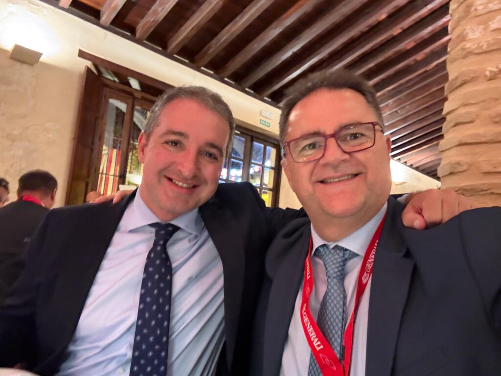 Dos asistentes a la Convención de Corredores GENERALI 2026 posan sonrientes en un salón con techo de vigas de madera.