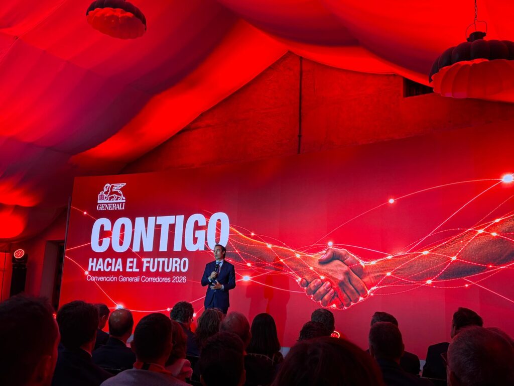 Ponente en el escenario de la Convención Generali Corredores 2026 ante el público, con la pantalla «Contigo hacia el futuro».